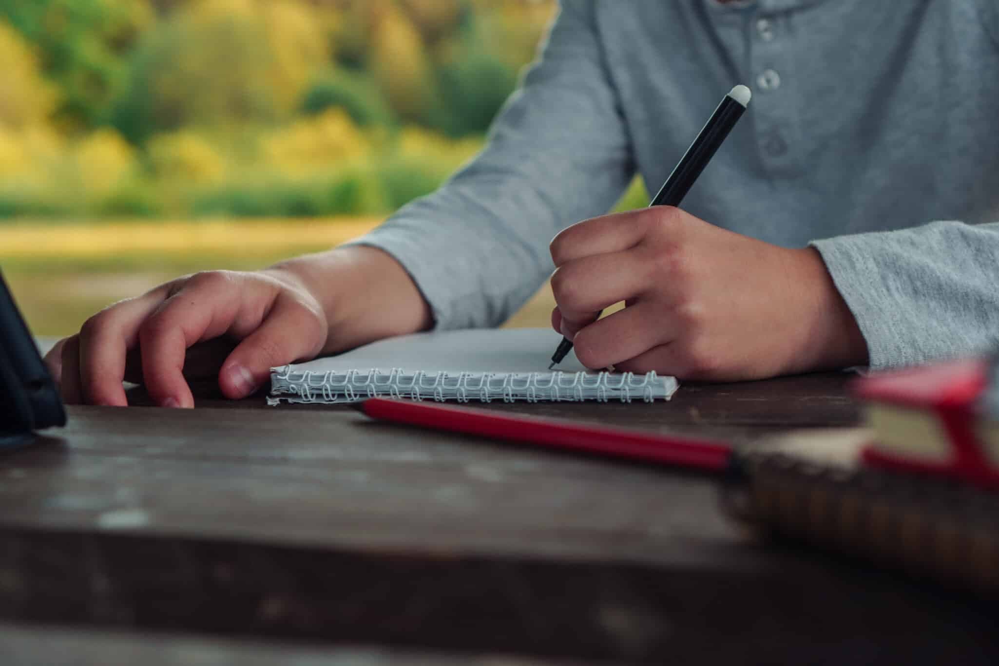 Person writing with their left hand, representing the genetic basis of left-handedness and health links
